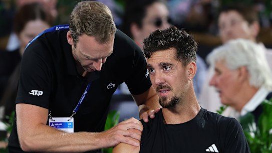 Thanasi Kokkinakis in the hands of a physio during his Adelaide International match against Sebastian Korda.