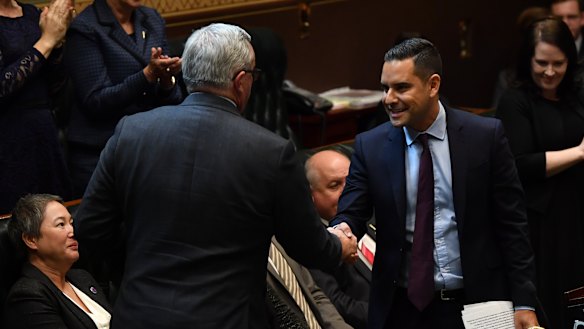 Independent MP Alex Greenwich shakes hands with Health Minister Brad Hazzard in the NSW Legislative Assembly after introducing the bill to decriminalise abortion.