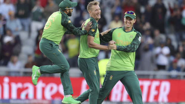 South Africa's Chris Morris, center, celebrates with teammates Dwaine Pretorius, right, and Tabraiz Shamsi after dismissing Australia's Alex Carey during the Cricket World Cup match.