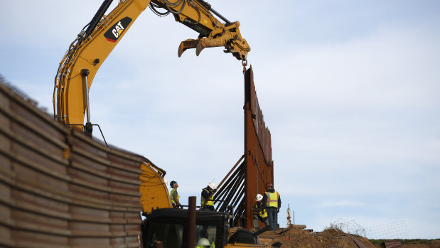Workers replace sections of the existing border wall in Tijuana, Mexico.