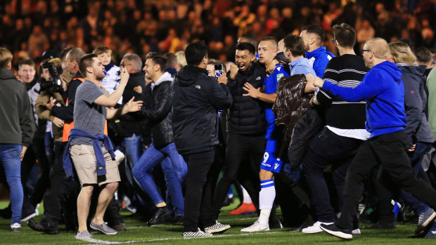Boilover: The crowd invades the pitch after Colchester sealed the victory.