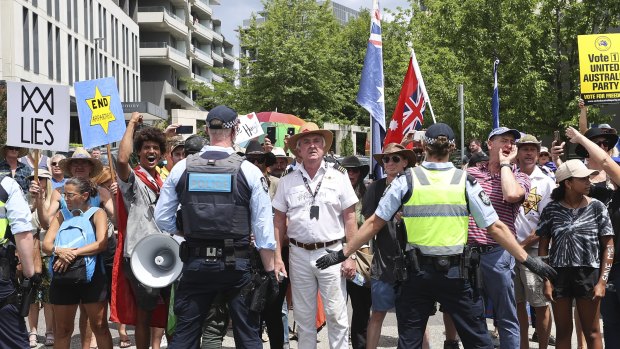 Former Qantas pilot Graham Hood (centre) stands among a crowd of protesters facing off with police on Tuesday.