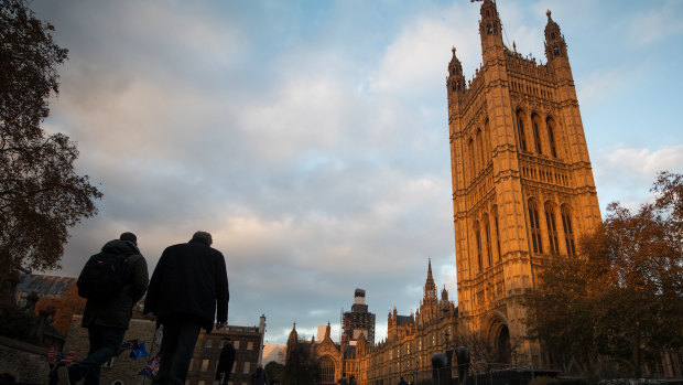 Pedestrians pass by the Houses of Parliament in London, on Wednesday.