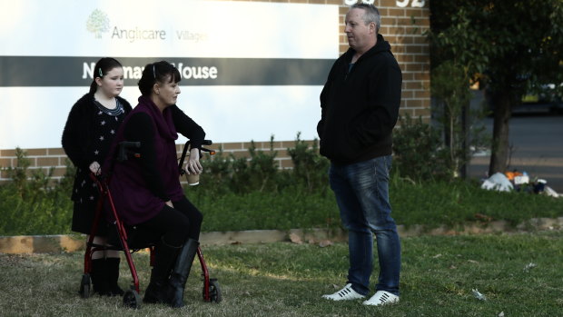 Relatives of residents Liz Lane with her daughter Samantha and Anthony Bowe gather outside Newmarch House on Tuesday.