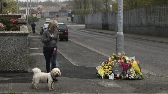Uneasy calm: A woman stops by a tribute for journalist Lyra McKee in Londonderry. 