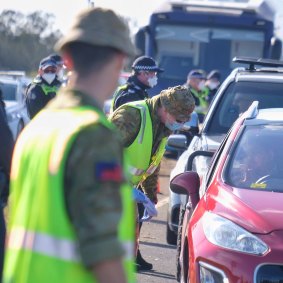 Members of the Australian Defence Force and Victoria Police at a vehicle checkpoint along the Princes Freeway near Little River.