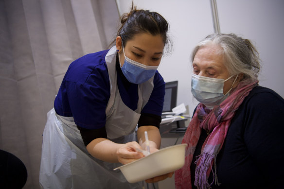 Jan Ireland, 73, is vaccinated by Jestine Lyra Lubrica at Melbourne Showgrounds on Wednesday.