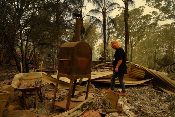 Anna Dunne walks through the remains of her home on the outskirts of Nelligen, where several homes and buildings were destroyed or damaged in the fire near Batemans Bay on New Year's Eve.