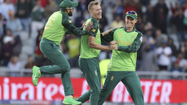 South Africa's Chris Morris, center, celebrates with teammates Dwaine Pretorius, right, and Tabraiz Shamsi after dismissing Australia's Alex Carey during the Cricket World Cup match.