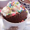 Molten chocolate mug cake with ice-cream and sprinkles.
