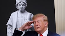 President Donald Trump salutes during the singing of the national anthem at a Columbus Day celebration.