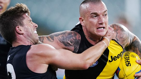 Richmond's Dustin Martin fends off Carlton's Marc Murphy in their first round encounter.