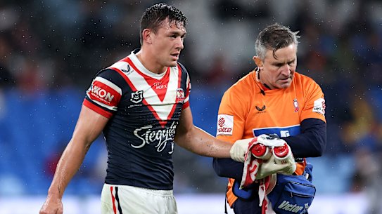 Joey Manu leaves the field with a suspected broken hand.