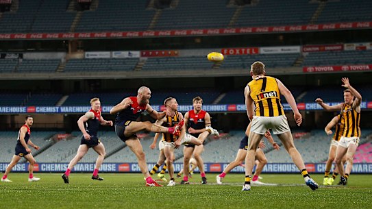 Max Gawn gets a kick away for the Demons in their draw with Hawthorn at a crowdless MCG.