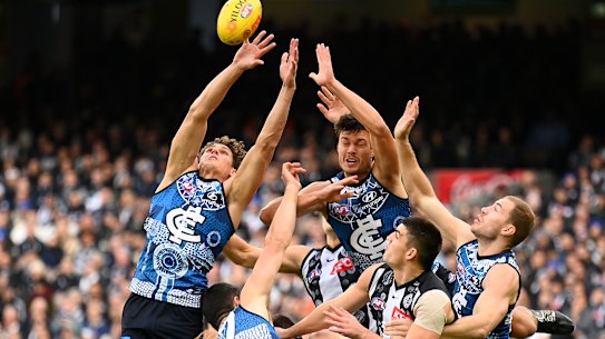 Blues and Magpies players fly for a mark.