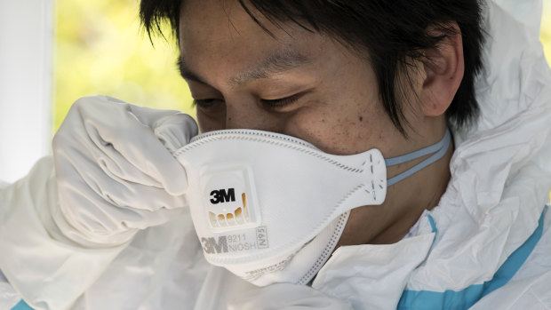 A staff member wears an N95 mask.