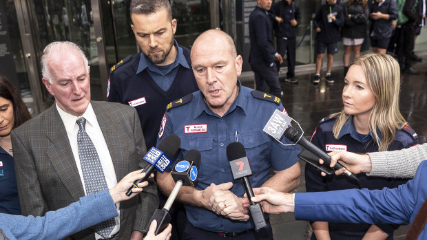 Paramedic Mick Stephenson (2nd right) talks to media  outside the Victoria County Court after two women were spared jail for assaulting paramedic Paul Judd (left) in 2016.  