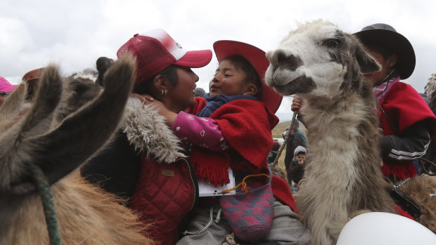 A mother embraces her child after he raced his llama at the Llanganates National Park in Ecuador.