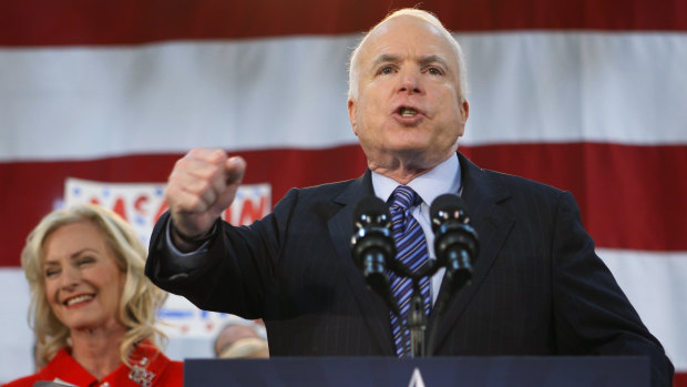 Republican presidential candidate Senator John McCain, standing with his wife Cindy, encourages his supporters to stand up and fight for America at the close of his address during a campaign rally in 2008.