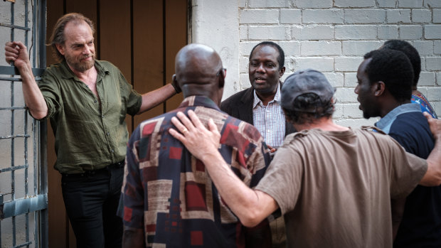 A war photographer played by Hugo Weaving listens to an African choir in Hearts and Bones. 