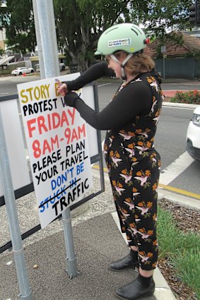 Protest organiser Kathryn Good removing a sign advising of a walk across the Story Bridge after a court ruled it could not go ahead.