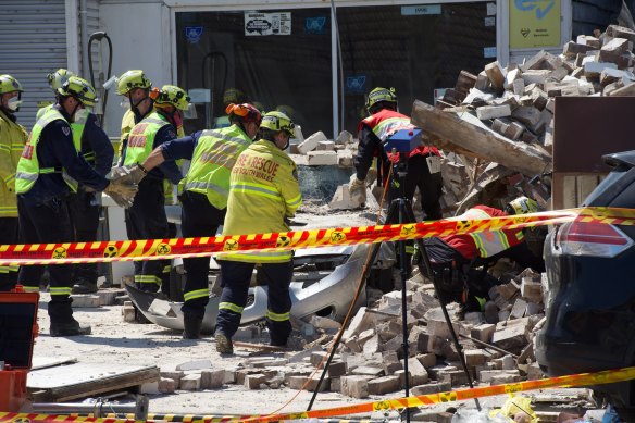 Emergency services workers at the site of the collapse.