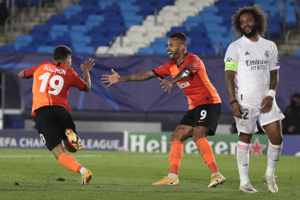 Shakhtar's Manor Solomon celebrates after scoring his side's third goal as Madrid's Marcelo Vieira looks on.