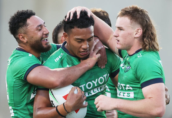 Peter Hola celebrates with his team after scoring for the Raiders.