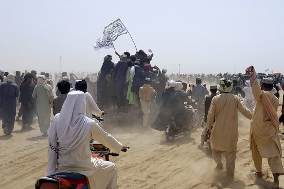 Supporters of the Taliban carry the Taliban’s signature white flags in the Afghan-Pakistan border town of Chaman on Wednesday.