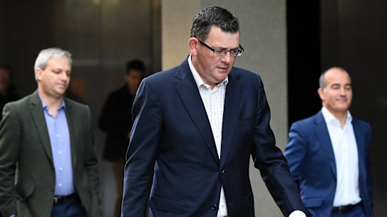 Victoria's Chief Health Officer  Brett Sutton (left), Premier Daniel Andrews and Education Minister James Merlino leave a press conference on Tuesday.