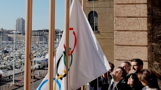 Mayor of Marseille Benoit Payan, centre, raises the Olympic flag with Head of Paris 2024 Olympics Tony Estanguet, centre right, after a press conference at the Marseille City Hall, southern France.
