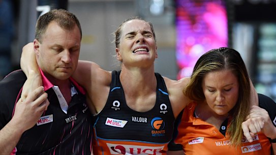 Kiera Austin is helped off the court after her injury.