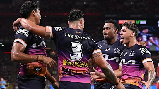The Broncos celebrate a try by winger Selwyn Cobbo (left).