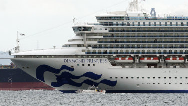 A small boat navigates near a cruise ship Diamond Princess anchoring off the Yokohama Port. Ten passengers have been confirmed to have a new virus.