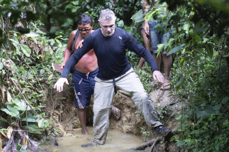 British journalist Dom Phillips, right, and a Yanomami Indigenous man walk in Maloca Papiu village, Roraima state, Brazil, in 2019.