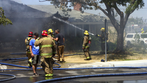 Kern County firefighters work to knock down a fire that severely damaged a home in Ridgecrest.