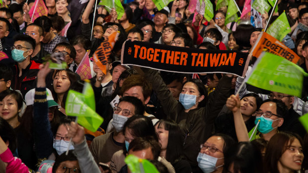 Attendees wave flags during a Democratic Progressive Party campaign rally with Taiwanese President Tsai Ing-wen in Taipei.