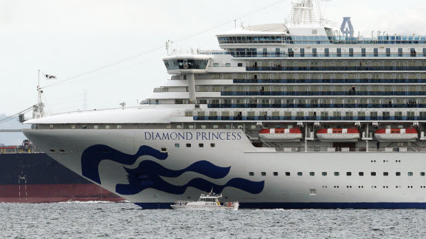 A small boat navigates near a cruise ship Diamond Princess anchoring off the Yokohama Port. Ten passengers have been confirmed to have a new virus.