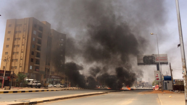 Burning tires set by protesters produce black smoke on road 60, near Khartoum's army headquarters, in Khartoum, Sudan, Monday.