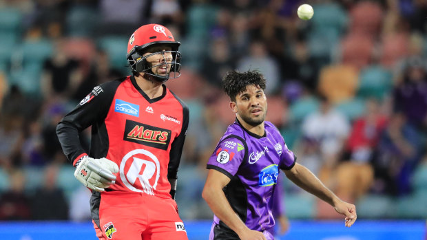 Tom Cooper of the Renegades (left) and Qais Ahmad of the Hurricanes during the Big Bash League (BBL) match at Blundstone Arena in Hobart, Thursday.