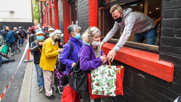 Collingwood legend and former coach Nathan Buckley hands out Christmas bags at the event.