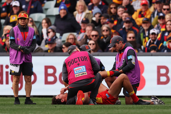 Gold Coast’s Wil Powell is treated by medicos on the field.