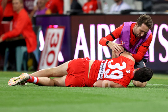 The Swans’ Paddy McCartin receives attention from a trainer after suffering another concussion.