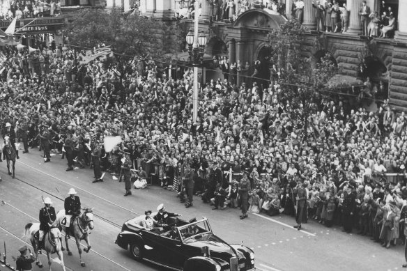 Large crowds watch the Queen and Prince Philip as they parade along Swanston Street.