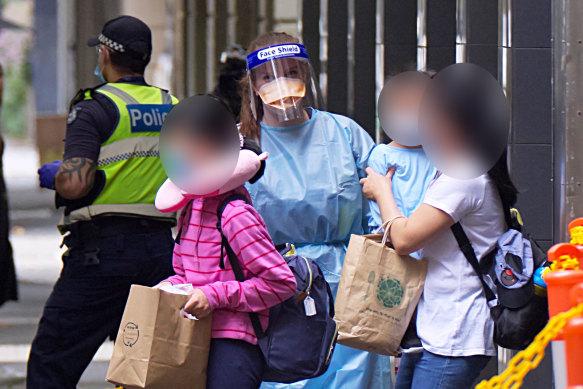 Staff escort guests from the Holiday Inn on Flinders Lane on Tuesday.