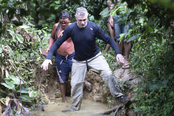 British journalist Dom Phillips, right, and a Yanomami Indigenous man walk in Maloca Papiu village, Roraima state, Brazil, in 2019.
