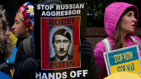 Supporters of Ukrainian sovereignty protest the Russian invasion with banners likening President Putin to Hitler.. 