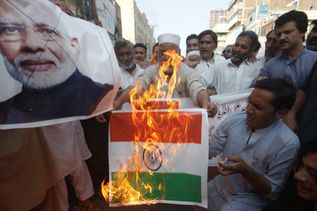 Pakistanis burn an Indian flag in protest over the Kashmir decree.