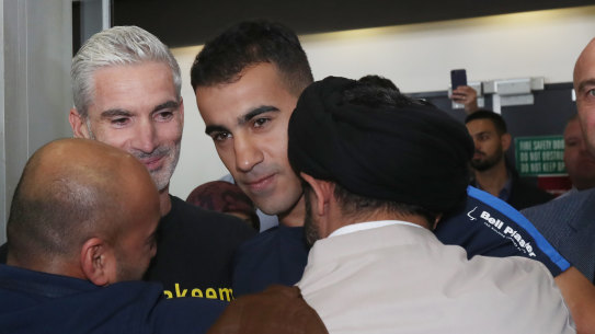 Former Socceroo Craig Foster (left) is seen with refugee footballer Hakeem Al-Araibi (centre) as he is greeted by supporters upon arriving at Melbourne International Airport in Melbourne, Tuesday, February 12, 2019.