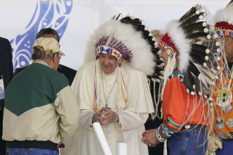 Pope Francis dons a headdress during a visit with indigenous peoples at Maskwaci, Canada.